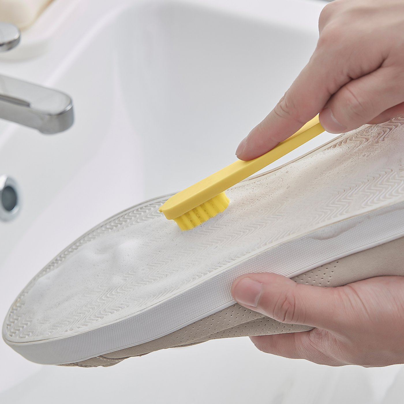 小さいブラシを靴底へ当てる使用例。靴や洗剤は付属しません。