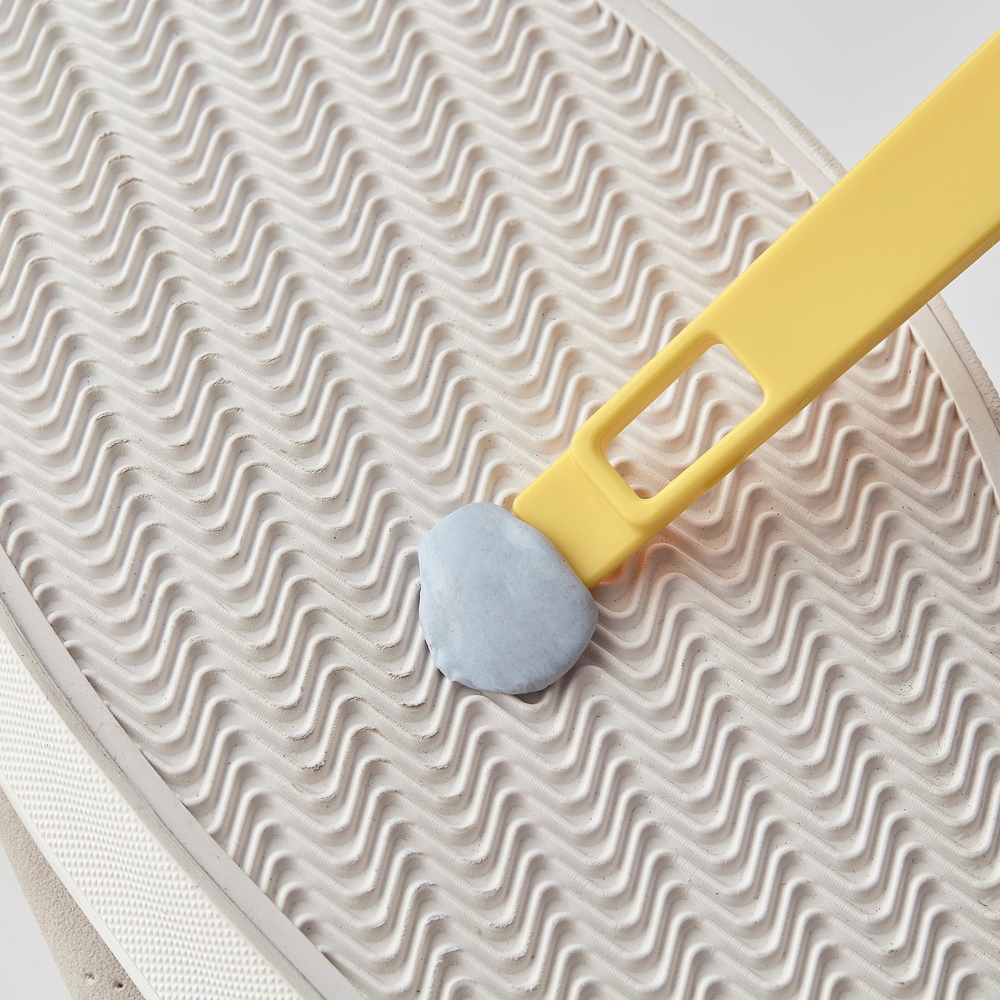 小さいブラシの柄の端にあるスクレーパーの使用例。