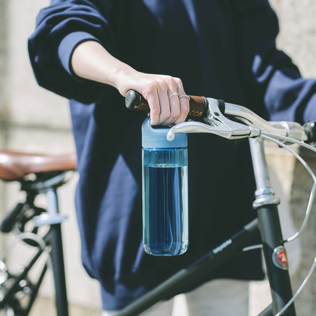 自転車のそばで手に持ったメーカー写真。走行しながら使用してよいという案内ではありません。