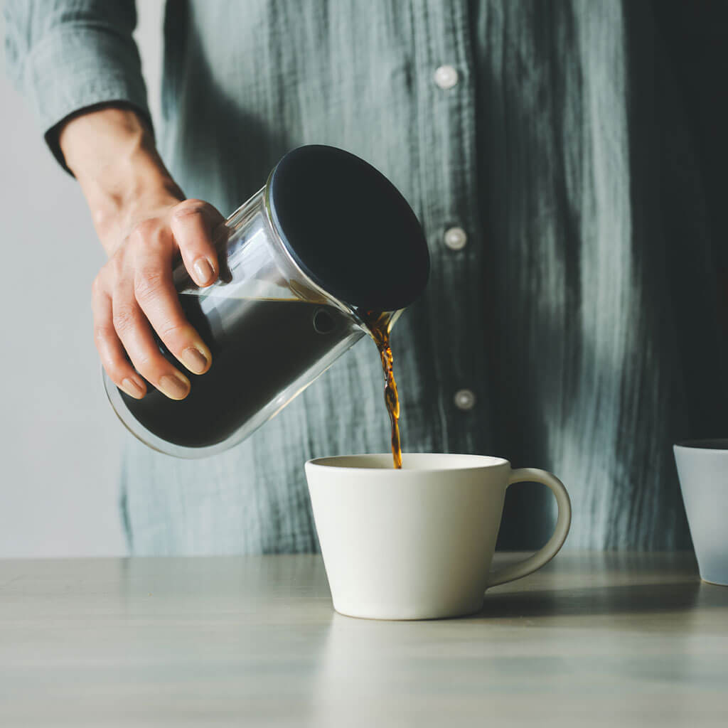フチの下を持ち、コーヒーをカップへ注ぐメーカー使用写真です。