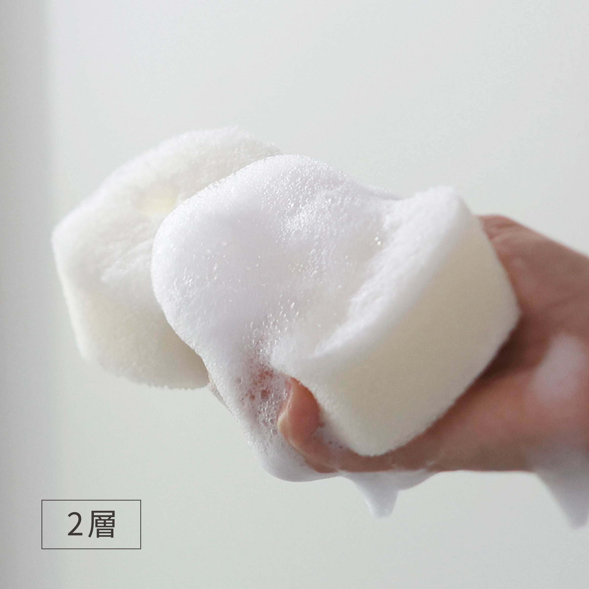 「2層」と明記されたメーカー使用写真。ウレタン層を握ったときの泡立ちを示しています。